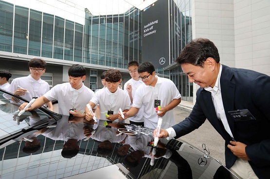 [사진 2] 메르세데스-마이바흐 S클래스 차량에 아우스빌둥에 임하는 포부를 적는 교육생들과 김지섭 부사장.JPG