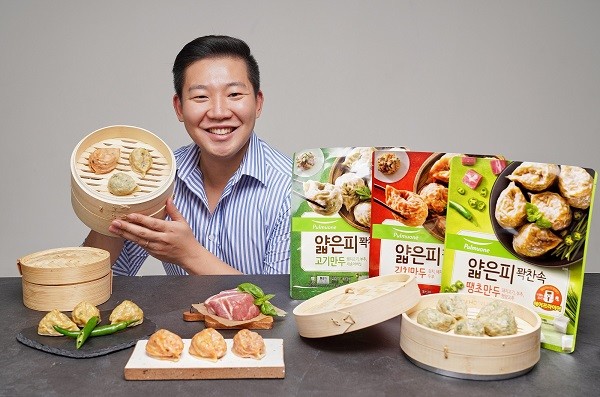 ▲풀무원식품 FRM사업부 홍태관 만두CM이 얄피만두 2000만 봉지 판매 돌파를 기념하며 얄피만두 3종을 들고 포즈를 취하고 있다.