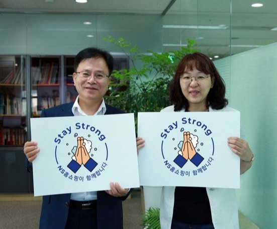 ▲조항목 NS홈쇼핑 부사장(왼쪽)이 임직원과 함께 스테이 스트롱 캠페인 로고팻말을 들고 있는 모습.