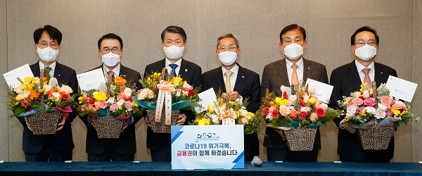 ▲ 은성수 금융위원장이 금융지주회장들에게 화훼농가를 돕기 위해 꽃바구니를 선물하고 있다. (왼쪽부터) 손병환 농협금융지주 회장, 조용병 신한금융지주 회장, 은성수 금융위원장, 윤종규 KB금융지주 회장, 김정태 하나금융지주 회장, 손태승 우리금융지주 회장