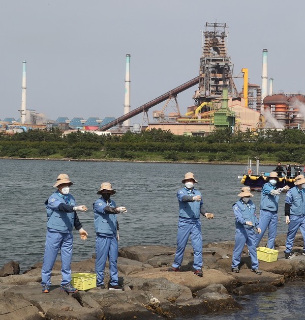 ▲포스코 최정우 회장이 1일 포항 형산강에서 포스코노동조합 18대 집행부와 함께 EM 흙공을 던지고 있다