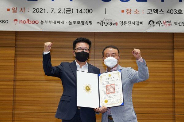 ▲제너시스BBQ 그룹 김태천 부회장(왼쪽)과 BBQ 강북스타점 남승우 패밀리