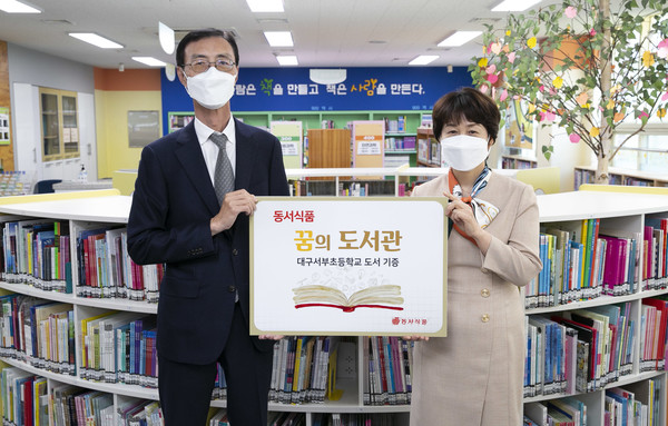 ▲3일 대구광역시 서구에 위치한 대구서부초등학교에서 진행된 2022 동서식품 꿈의도서관’ 도서 기증식에서 동서식품 최상인 홍보상무(왼쪽)와 대구서부초 이미경 교장(오른쪽)이 기념사진을 촬영하고 있다