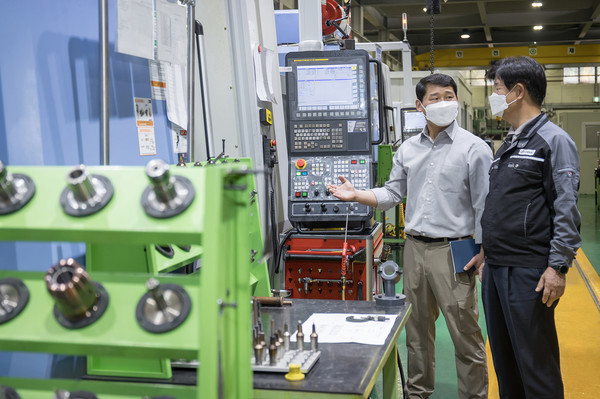 ▲ 경기도 안산시에 위치한 금형생산기업 건우정공에서 박순황 회장(오른쪽)과   삼성전자 스마트공장지원센터 김극 프로(왼쪽)가 CNC 가공설비를 살펴보고 있다