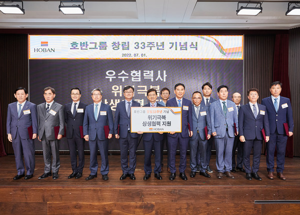 ▲ 김선규 호반그룹 회장(왼쪽에서 여섯 번째), 김재환 신세계전기 대표(왼쪽에서 열한 번째) 등 관계자들이 위기극복 지원금 전달 후 기념사진을 찍고 있다