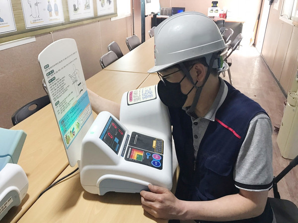 ▲ 태백 부영아파트 신축공사 현장에서 한 근로자가업무 투입 전 건강 체크를 하고 있다