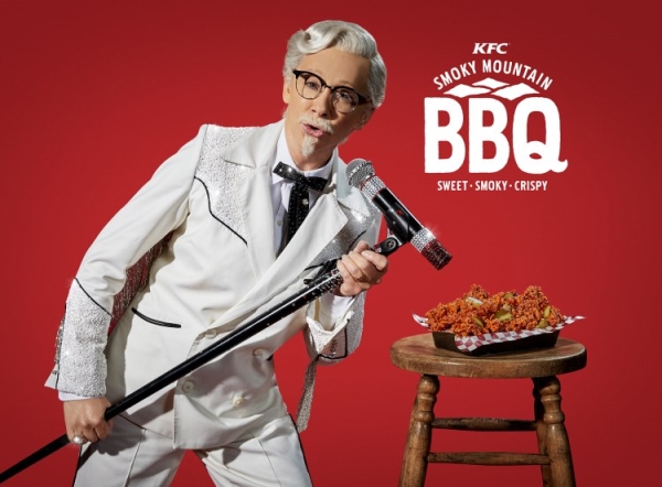 ▲KFC 마스코트 커널 샌더스로 변신한 리바 매킨타이어가 2018년 미국에서 출시돼 현지에서 가장 많이 팔린 치킨 '스모키 마운틴 BBQ'를 홍보하고 있다