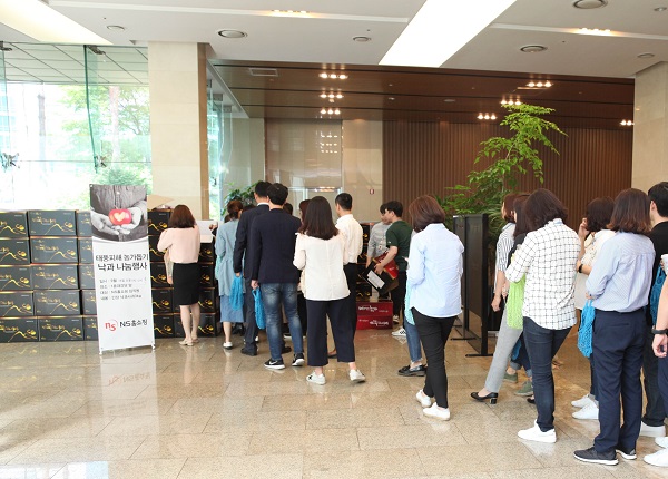 ▲2018년 NS홈쇼핑 낙과 나눔행사에서 임직원들이 줄을 선 모습
