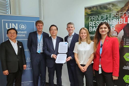 ▲ 우리금융그룹은 지난 6일 스위스 제네바 소재 UNEP FI 본부에서 ‘NZBA(넷제로은행연합) 이니셔티브’에 가입했다. 손태승 우리금융그룹 회장(왼쪽에서 세번째)과 에릭 어셔 UNEP FI 대표(오른쪽에서 세번째)가 NZBA 가입서를 들고 기념촬영을 하고 있다.