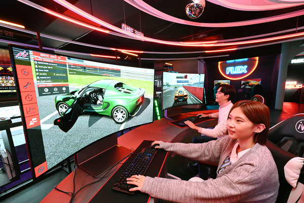 ▲모델들이 시청환경에 맞춰 자유롭게 화면을 구부렸다 펼 수 있는 LG 올레드 플렉스로 게임을 즐기고 있는 모습.