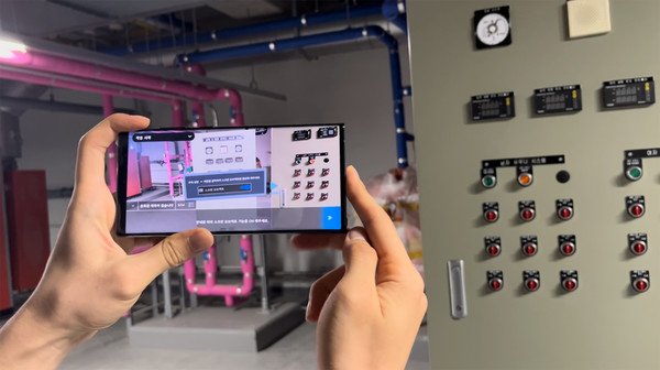 ▲ 롯데건설 관계자가 증강 현실(AR) 기반 가상 가동 시스템을 시연하고 있다.