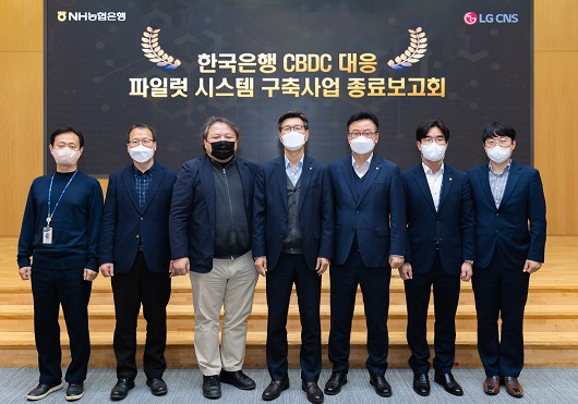 ▲ 13일 농협은행 본사에서 개최된 CBDC 대응 파일럿테스트 종료보고회에 참석한 이상래 NH농협은행 부행장(왼쪽 네 번째)과 직원들, LG CNS 관계자들이 기념촬영을 하고 있다.