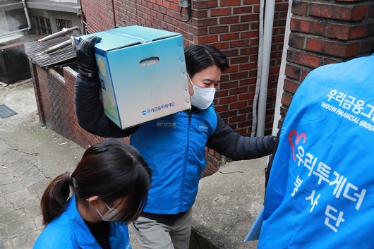 ▲ 우리금융미래재단 직원들이 새해를 맞아 독거어르신에게 우리 새해 복꾸러미를 전달하고 있다.