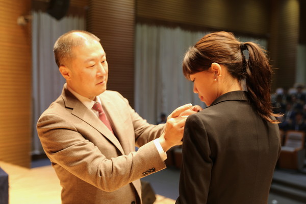 신입사원에게 LS 뱃지를 달아주고 있는 구자은 회장