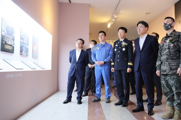 ▲최정우 포스코그룹 회장(사진 오른쪽에서 두번째)과 포항제철소 복구 유공기관 관계자들이 지난 10일 포항 포스코 본사에서 포항제철소 복구과정을 담은 사진전 '2022년 아픔을 잊고, 미래를 잇다'를 관람하고 있다.