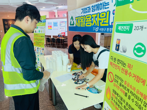 ▲오비맥주 청주공장 임직원이 재활용 자원 교환사업에 참여해 폐건전지를 교환하고 있다