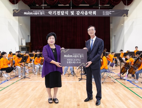 ▲10월31일 대전 대덕구 대전동도초등학교에서 열린 ‘제17회 맥심 사랑의 향기’ 행사에서 동서식품 최상인 홍보상무(오른쪽)와 대전동도초등학교 강창숙 교장이 기념촬영을 하고 있다