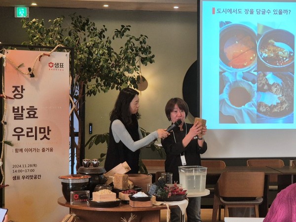 ▲이홍란 샘표 우리맛연구중심 연구원(오른쪽)이 메주를 들고 장 담그는 법을 설명하고 있다