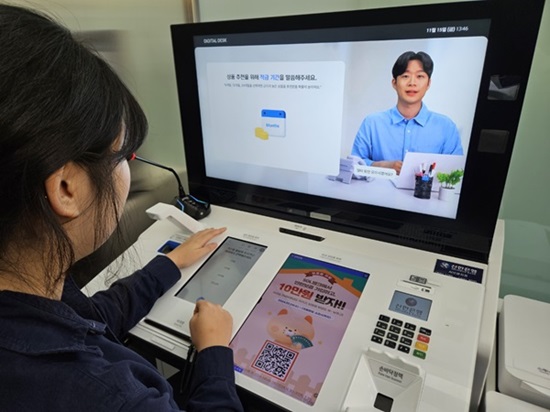 ▲ 신한은행 AI 브랜치를 방문한 고객이 AI은행원 창구에서 업무를 수행하고 있다.