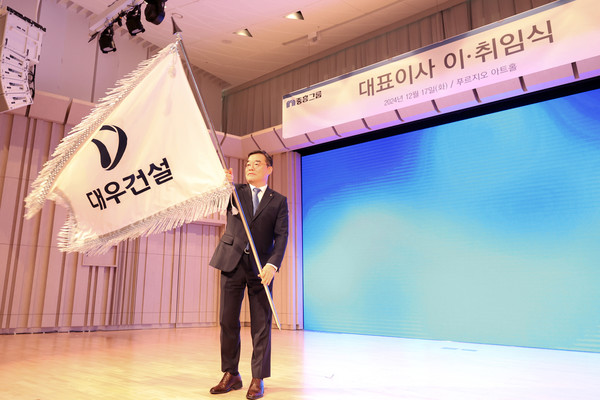 ▲지난 17일, 대우건설 푸르지오 아트홀에서 개최된 대표이사 이·취임식에서 김보현 사장이 대우건설 사기를 흔들고 있다.