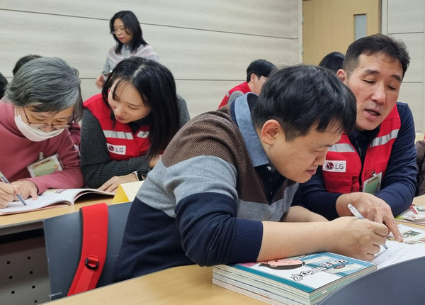 ▲지난 12월 서울 강남구 충현복지관에서 열린 ‘쉬운 가전 프로젝트’에 참여한 LG전자 임직원 봉사자와 장애인 참가자들의 모습