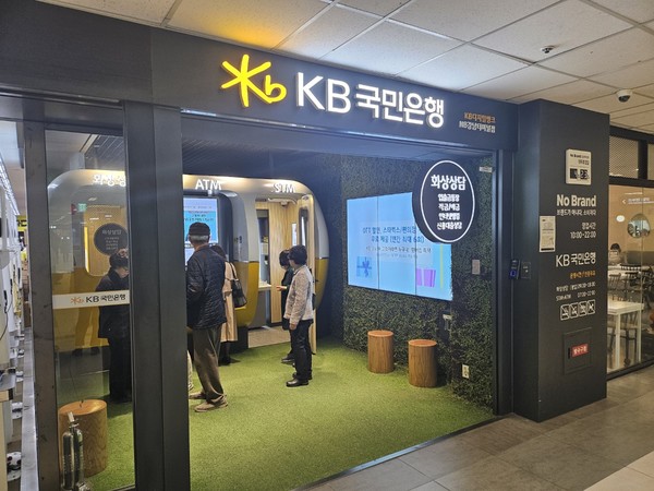▲KB디지털뱅크 NB강남터미널점. 매장 입구에 은행 ATM기기를 이용하려는 고객 여러 명이 서 있다.