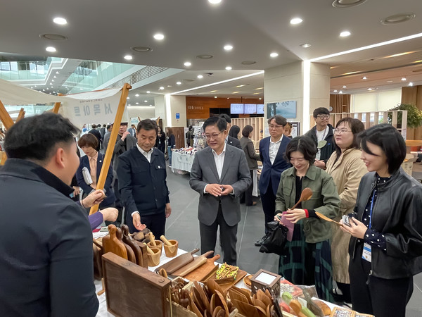 ▲권명호 한국동서발전 사장과 김영길 울산 중구청장, 직원들이 함께 물품을 구경하고 있다