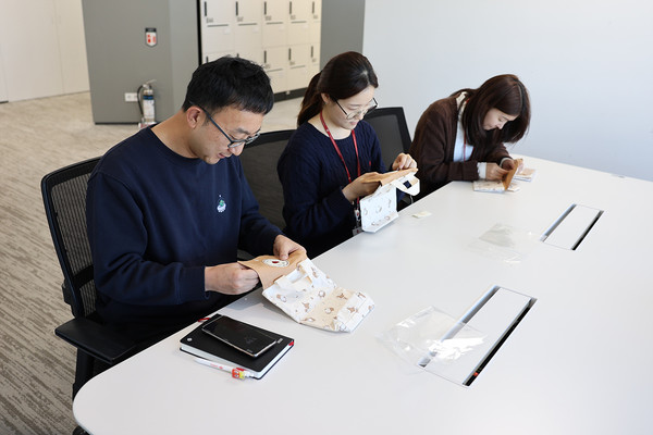 ▲기저귀 파우치를 직접 만들고 있는 롯데물산 임직원들