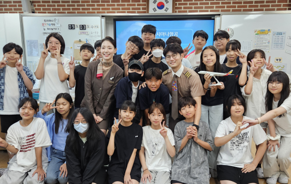 ▲이민정 아시아나항공 부사무장(사진 가운데 왼쪽)과 이동준 아시아나항공 부기장이 지난 9월 3일 서울공진초등학교에서 열린 항공진로 직업특강에서 학생들과 기념촬영을 하고 있다.