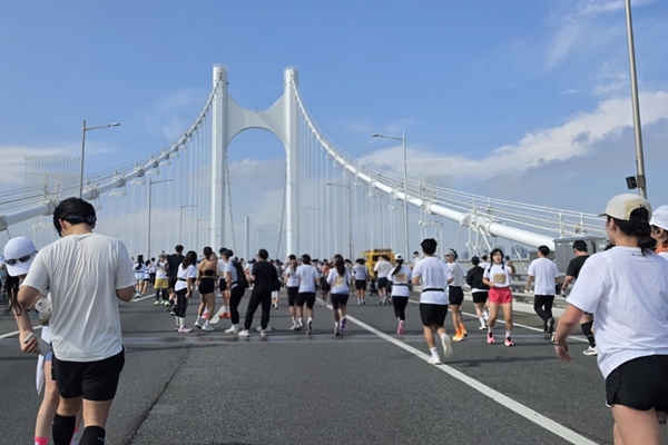▲광안대교를 배경으로 기념촬영하고 있는 참가자들의 모습. 사진=임규도 기자 
